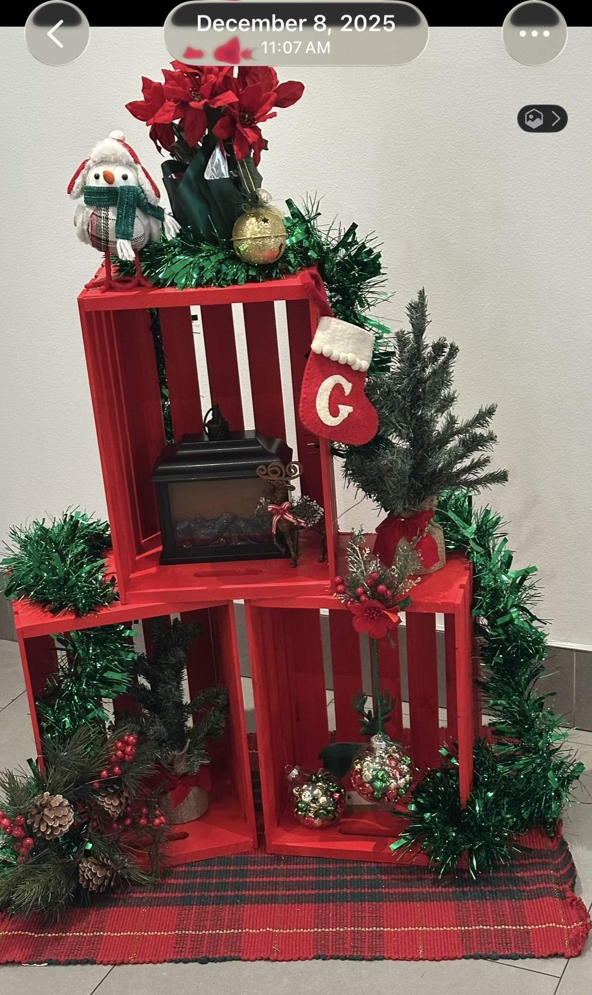 Christmas display in Goldtex lobby, December 8, 2025 — red crates, poinsettia, garland, snowman