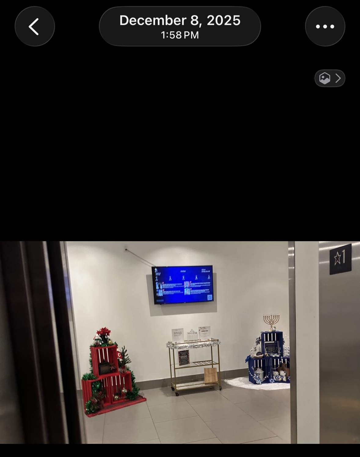 Wide shot of both holiday displays in Goldtex lobby, flanking the bar cart opposite the elevators