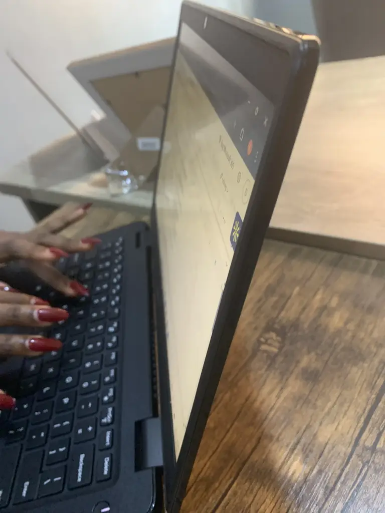 Standing Binatone Fan’ A bag, table and chair and laptop